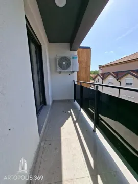 Pogled na natkriveni balkon sa staklenom ogradom i spoljnom jedinicom klima uređaja. - image 18