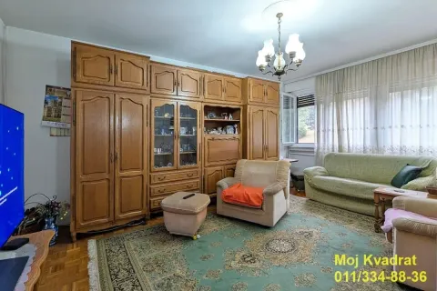 Dnevna soba sa garniturom, velikim drvenim ormarom i tepihom. - image 2