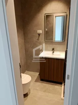 Pogled na moderno opremljeno kupatilo sa umivaonikom, ogledalom i WC šoljom. - image 6