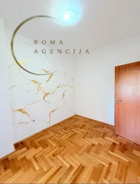 Empty room with parquet flooring and a decorative accent wall. - image 3