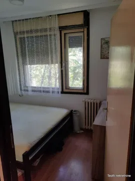 Manja spavaća soba sa krevetom i prozorom koji gleda na zelenilo. - image 14