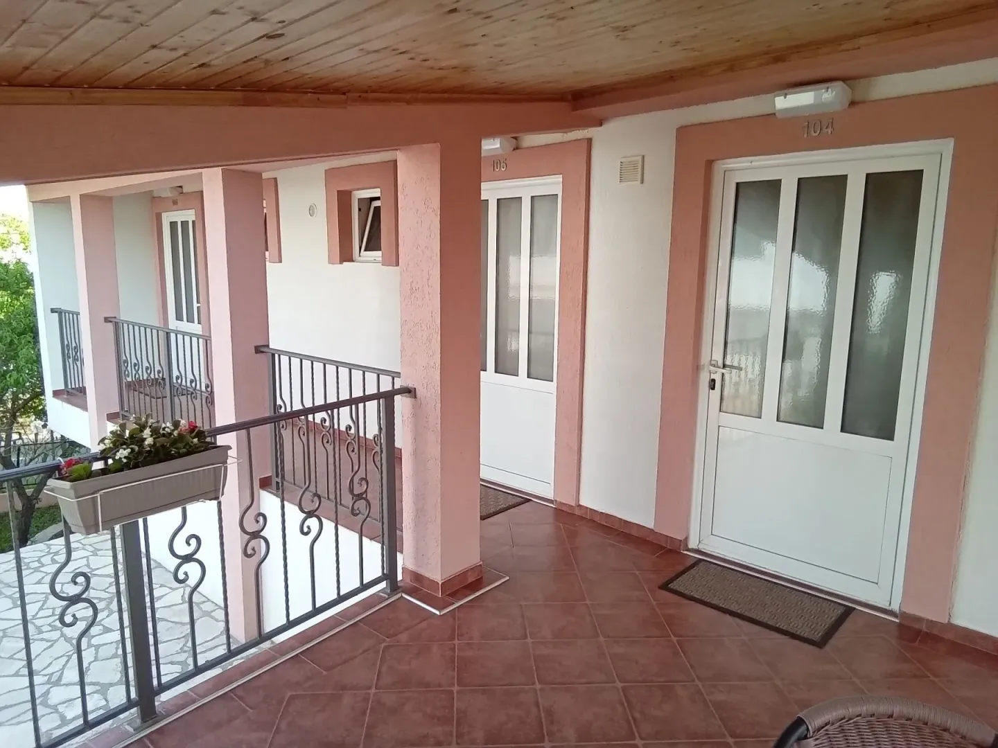 Natkriveni trem i hodnik sa ulaznim vratima u apartmane.