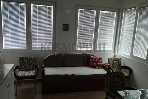 Living room with a sofa and large windows with blinds. - image 3
