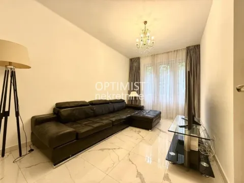 Living room with a black leather sofa and a TV. - image 5