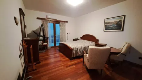 Spavaća soba sa bračnim krevetom, drvenim namještajem i izlazom na balkon. - image 12