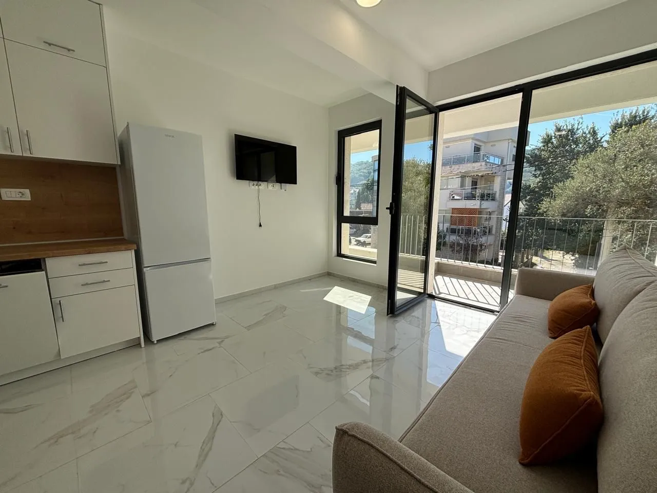 Living room with a kitchen and access to the terrace.