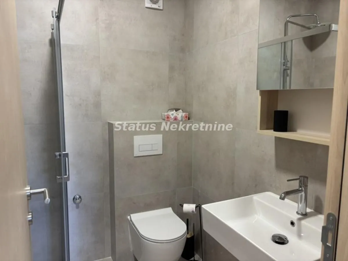 Moderno opremljeno kupatilo sa tuš kabinom, umivaonikom i wc šoljom.