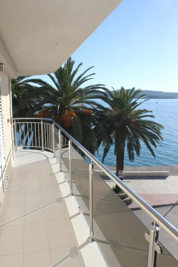 Spacious terrace with a view of the sea and palm trees.