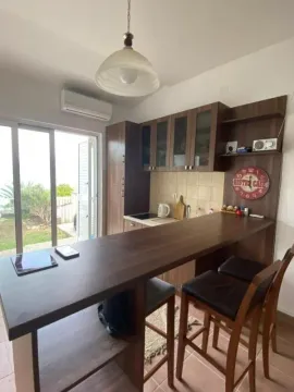 Kuhinja sa šankom i trpezarijskim stolicama i izlazom na dvorište. - image 11