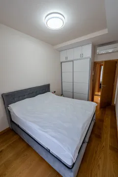 Bedroom with a double bed, built-in wardrobe, and wooden flooring. - image 8