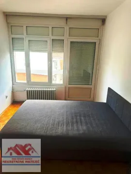 Bedroom with a double bed and a window with blinds. - image 5
