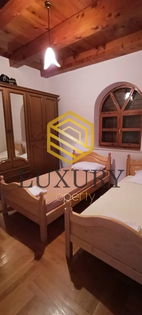Bedroom with two wooden beds and a wardrobe.