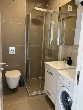 Moderno opremljeno kupatilo sa tuš kabinom i veš mašinom. - image 6