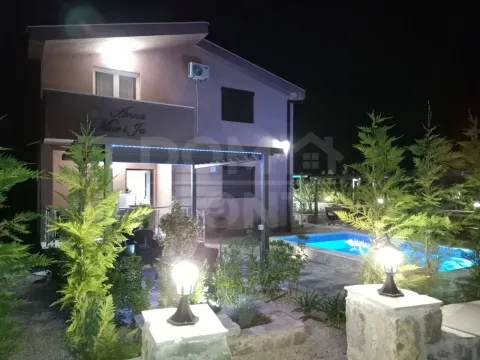 Exterior of the house at night with a yard, swimming pool, and lighting. - image 5