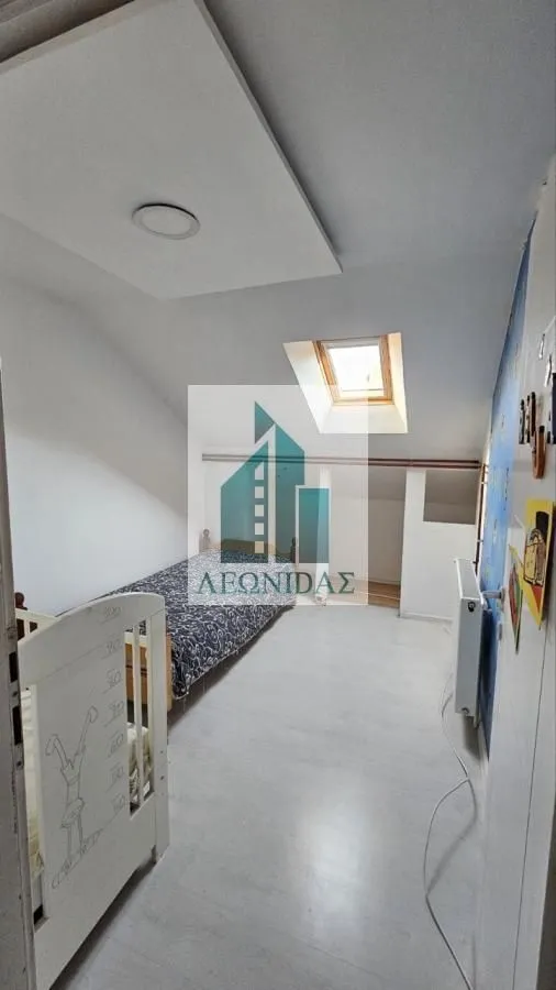 Children's bedroom with a bed and a skylight in the attic.