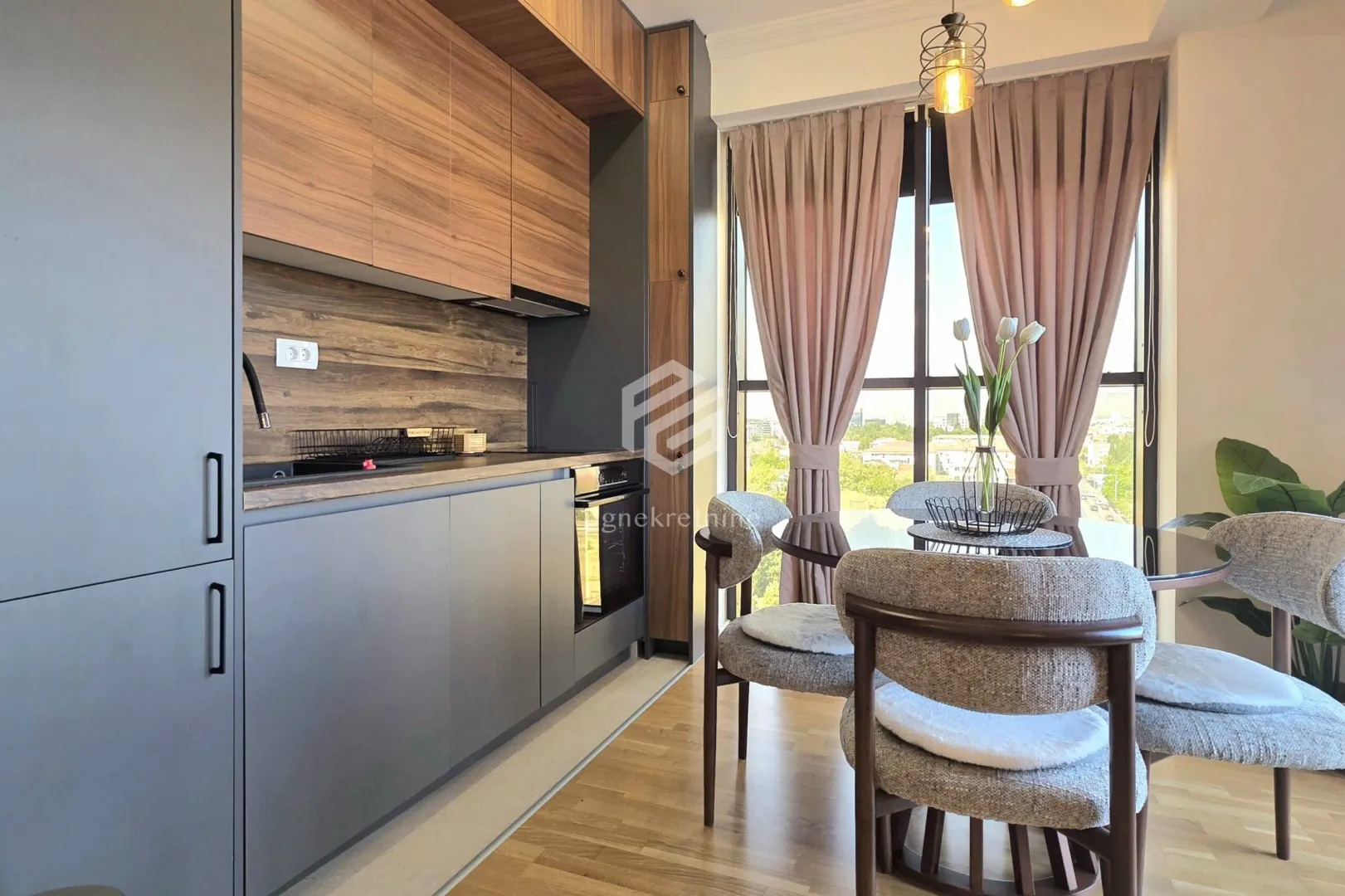 Modern kitchen with wooden elements and a dining table by the window.