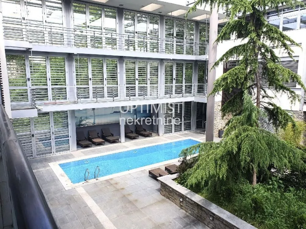 View of the building exterior with a swimming pool and landscaped courtyard.