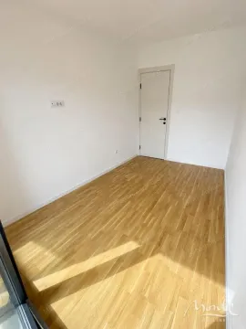 Prazna svijetla prostorija sa parketom na podu i bijelim zidovima. - image 6
