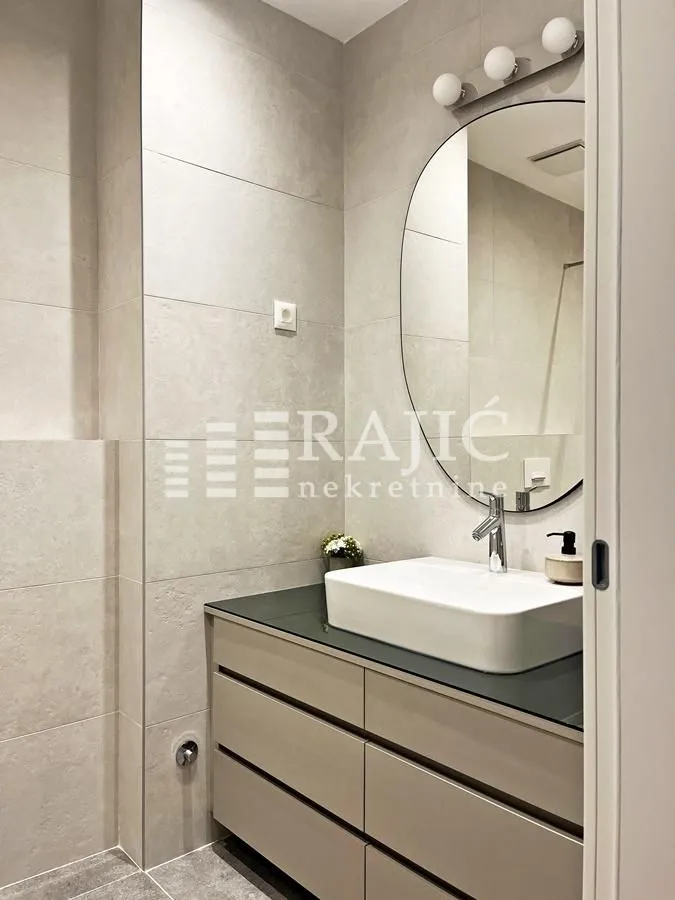 Modern bathroom equipped with a washbasin and mirror.