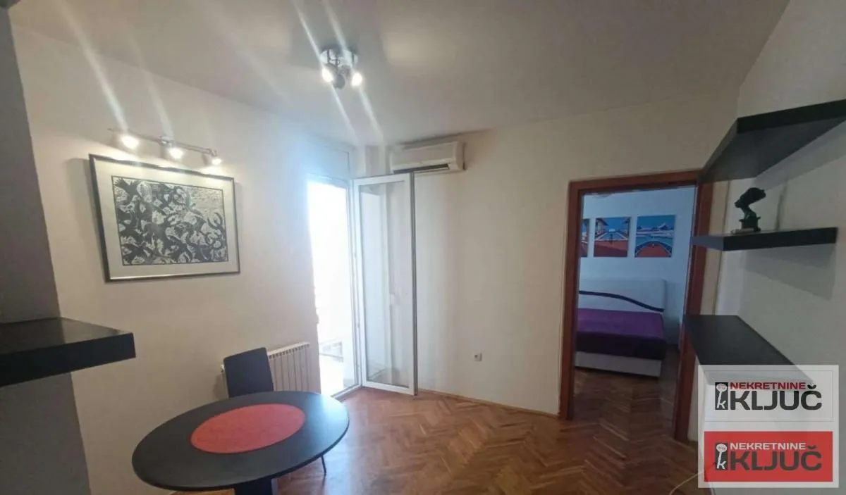 Dnevna soba sa trpezarijskim stolom i izlazom na terasu.