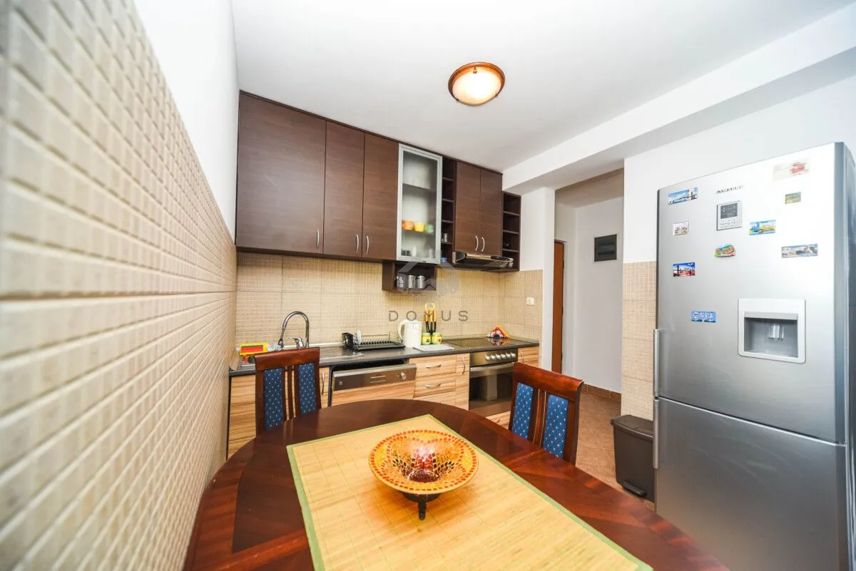 Kitchen with a dining table and wooden cabinets.