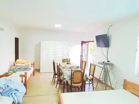 Living room with dining area and beds. - image 4