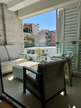 Furnished terrace with seating furniture and a view of surrounding buildings. - image 2