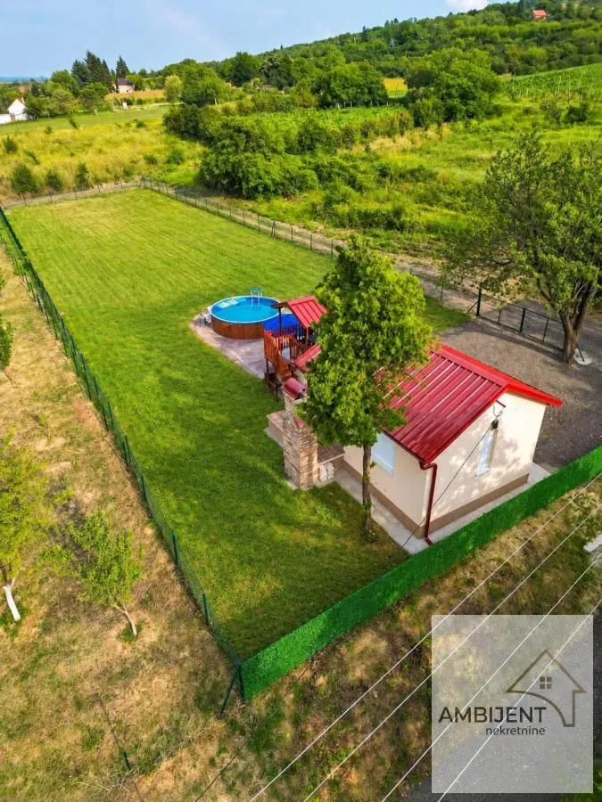 Pogled iz vazduha na ograđeno dvorište sa kućom i bazenom.