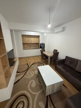 Living room with a sofa set, dining area, and a fitted kitchen in the background. - image 4