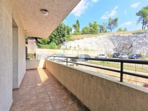 Spacious tiled balcony overlooking the parking area and surrounding greenery. - image 6