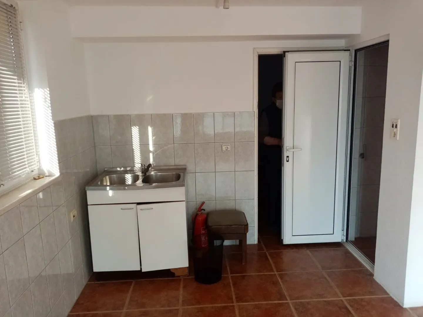 Simple kitchen with a sink and tiled walls.