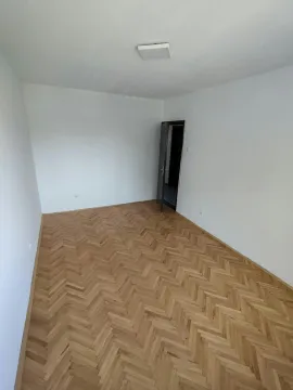 Prazna soba sa belim zidovima i drvenim parketom. - image 8