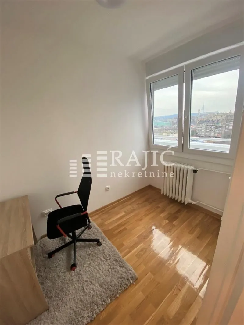 Empty room with hardwood floors, desk, and chair.