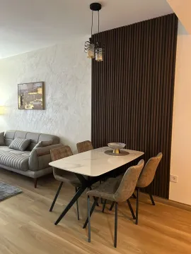 Dnevni boravak sa trpezarijom i modernim drvenim panelima na zidu. - image 15