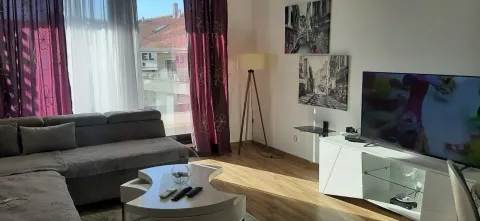 Living room with a sofa, TV, and coffee table. - image 3
