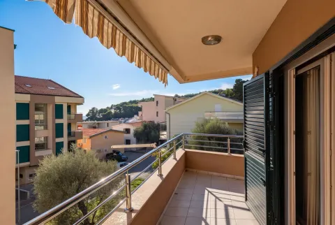 Spacious balcony with a view of surrounding buildings and greenery. - image 5