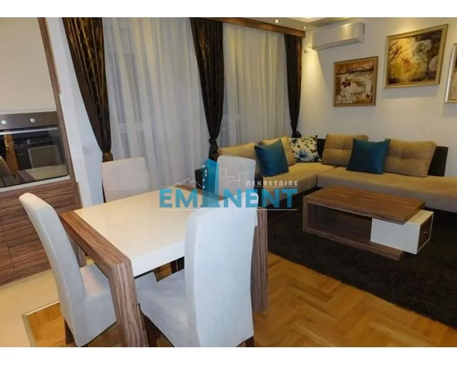 Living room with a sofa set, dining table and chairs.