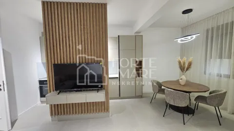 Dnevni boravak sa trpezarijom i modernim drvenim panelom na zidu. - image 5