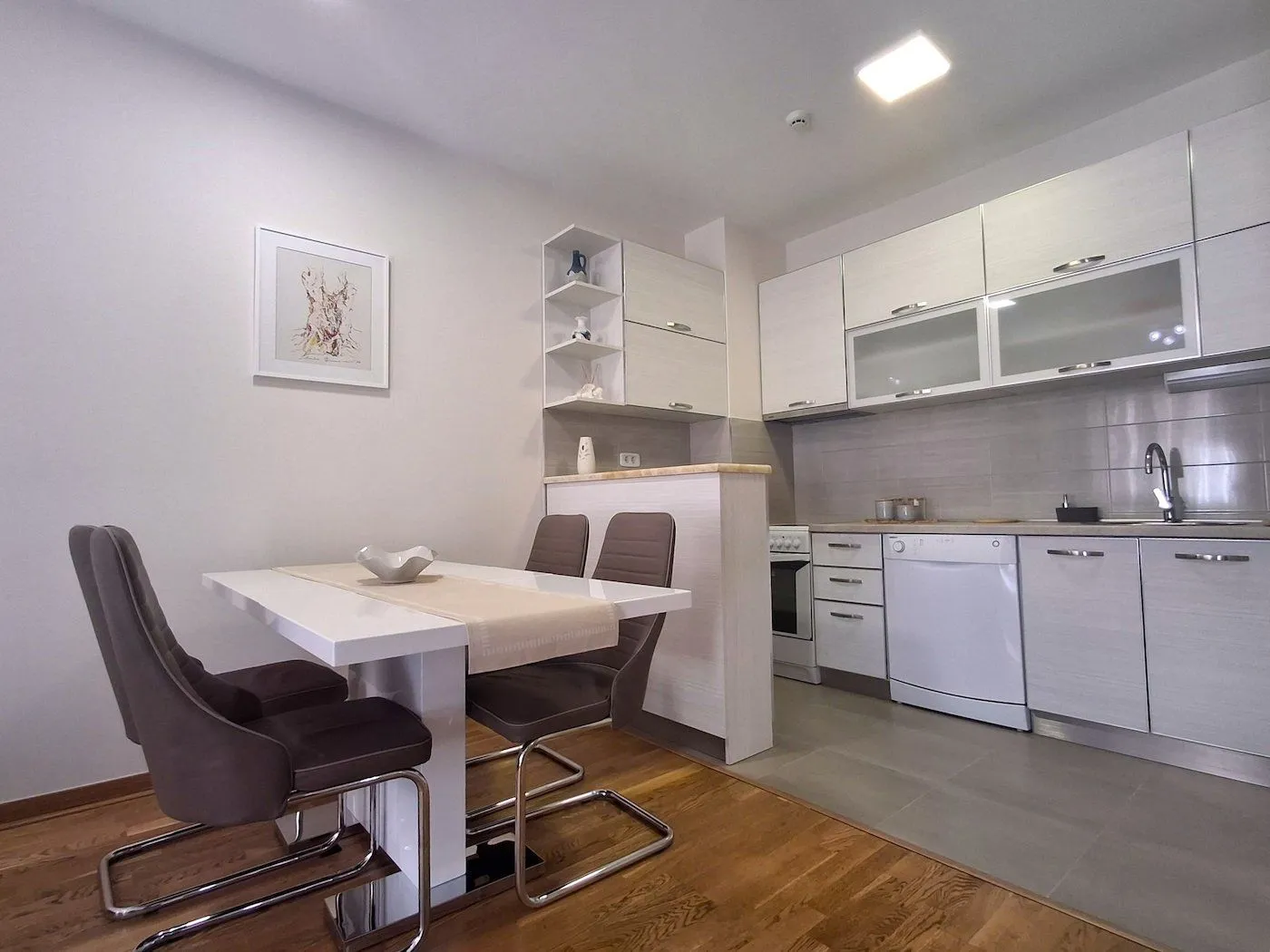 Modern kitchen with dining area and white cabinetry.