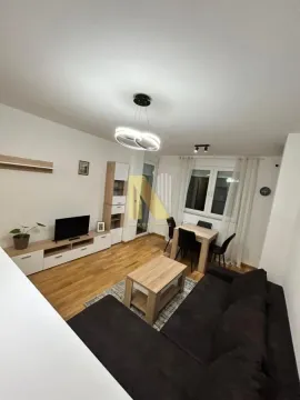 Prostrana dnevna soba sa garniturom, televizorom i trpezarijskim stolom. - image 12