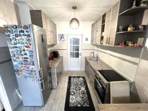 Compact kitchen with wooden cabinets, refrigerator, and built-in appliances. - image 4