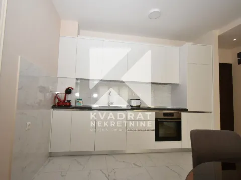 Modern white kitchen with a built-in oven and sink. - image 5