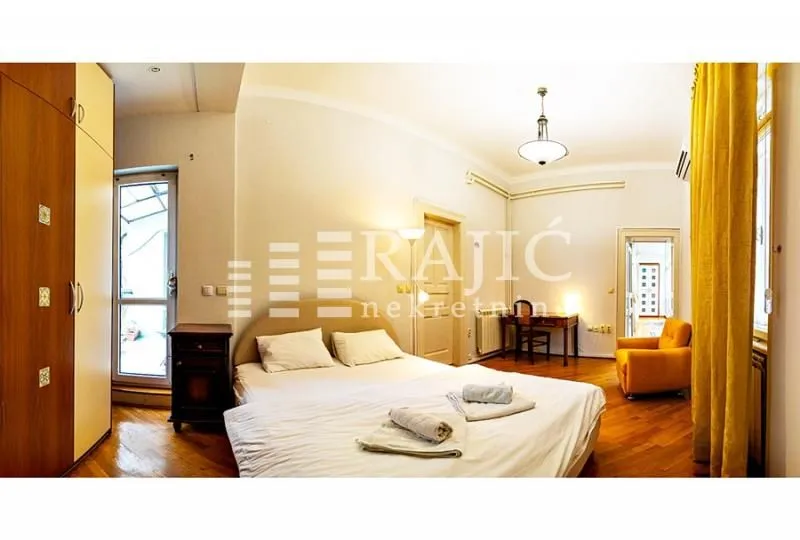 Spacious bedroom with a double bed, wardrobe, and a desk.
