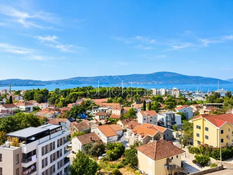 Pogled sa nekretnine na grad, okolno zelenilo i more u daljini. - image 2