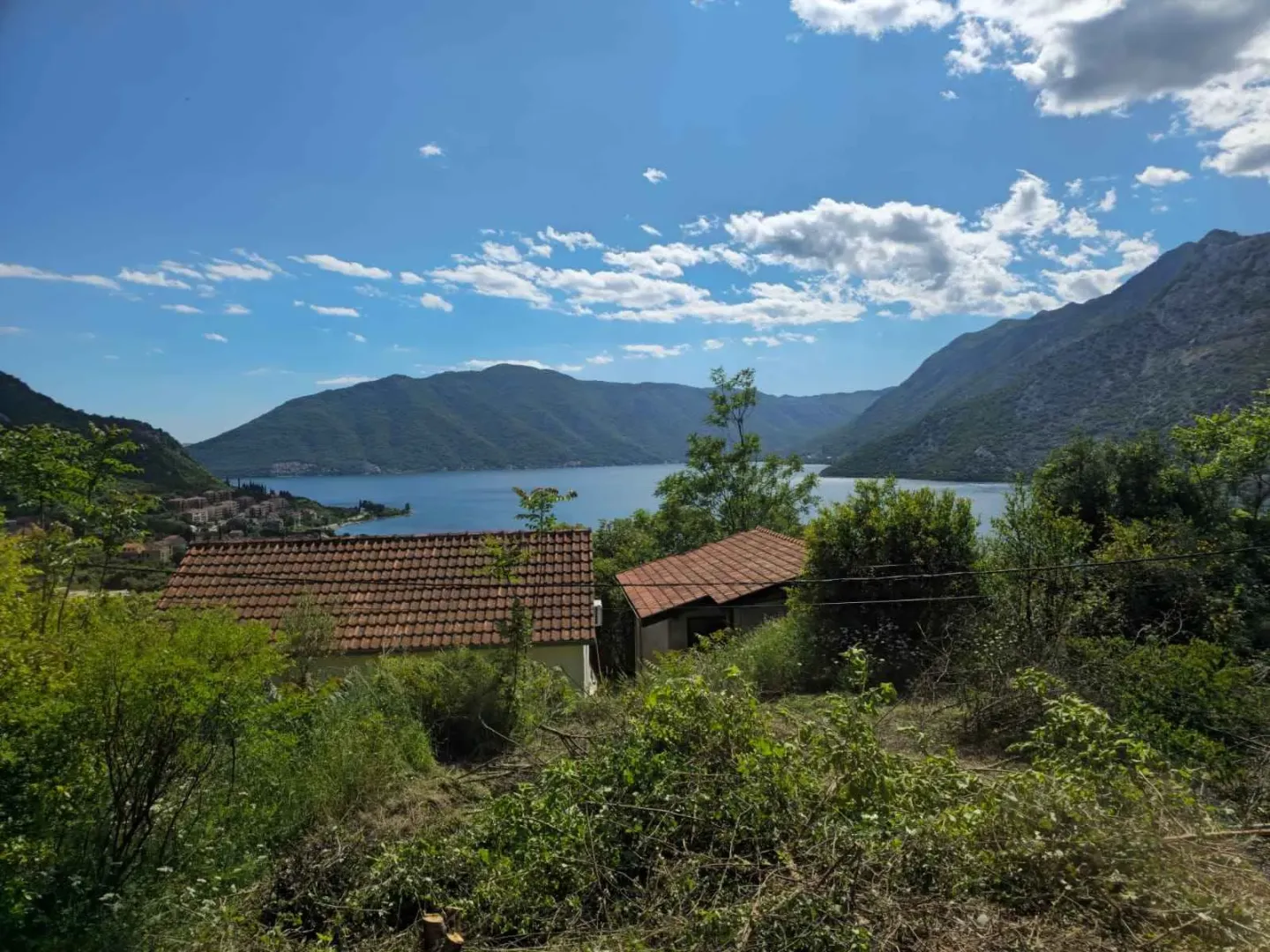 Pogled na kuće i zaliv okružen planinama.
