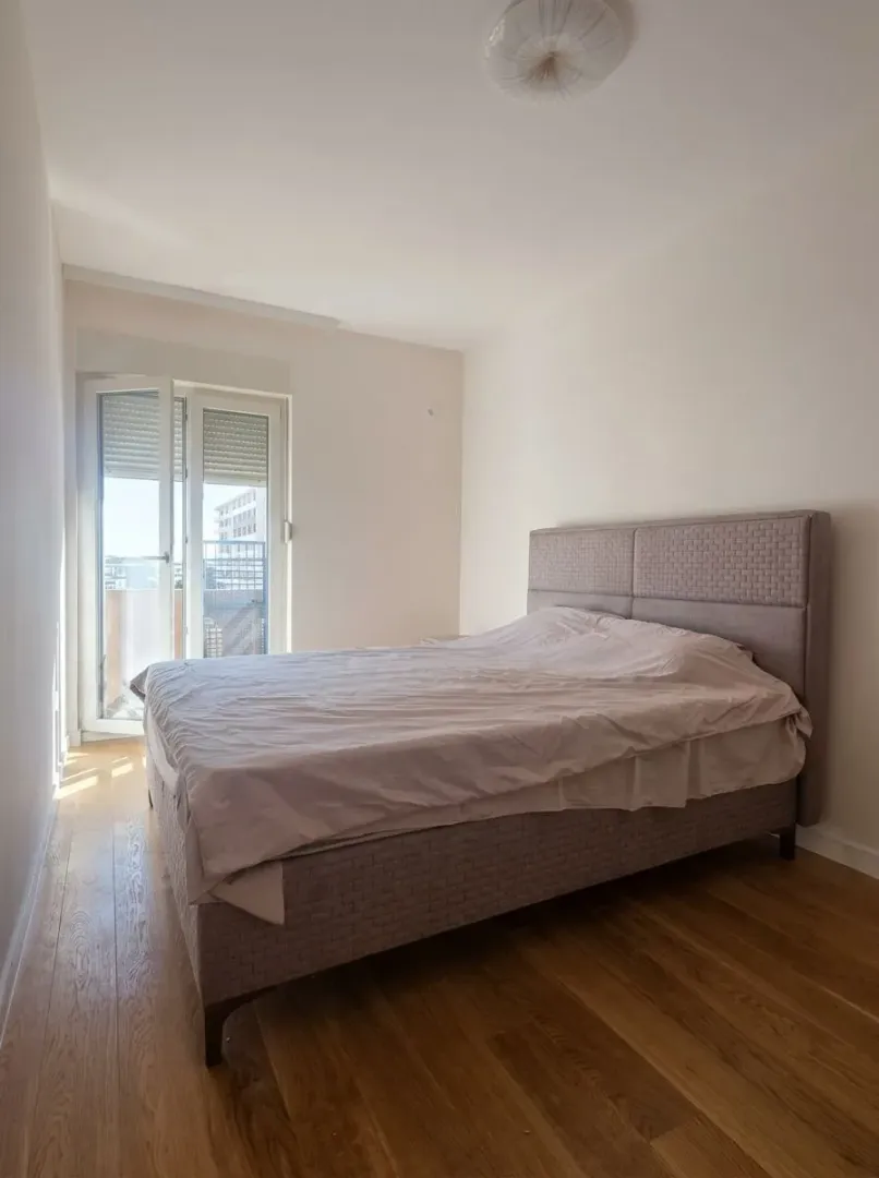 Bright bedroom with a double bed and access to the terrace.