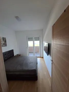 Namještena spavaća soba sa bračnim krevetom, televizorom i izlazom na terasu. - image 11