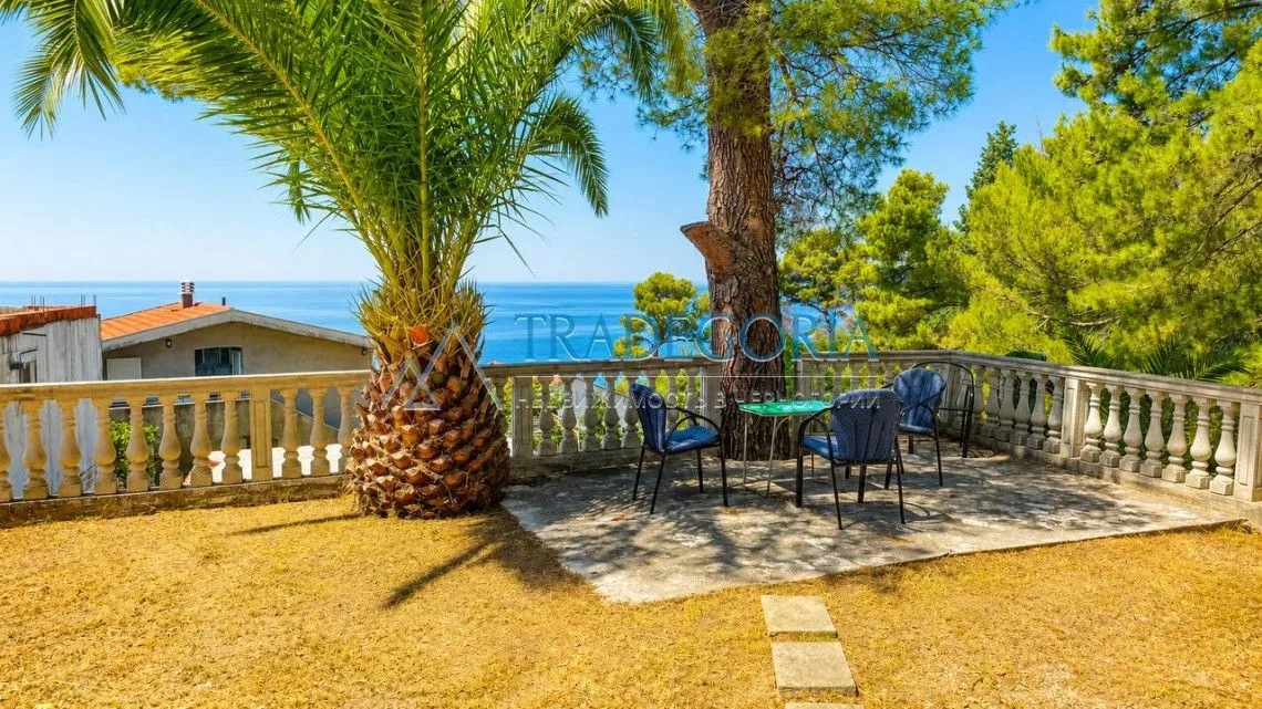 Yard terrace with a table, chairs, and a sea view.