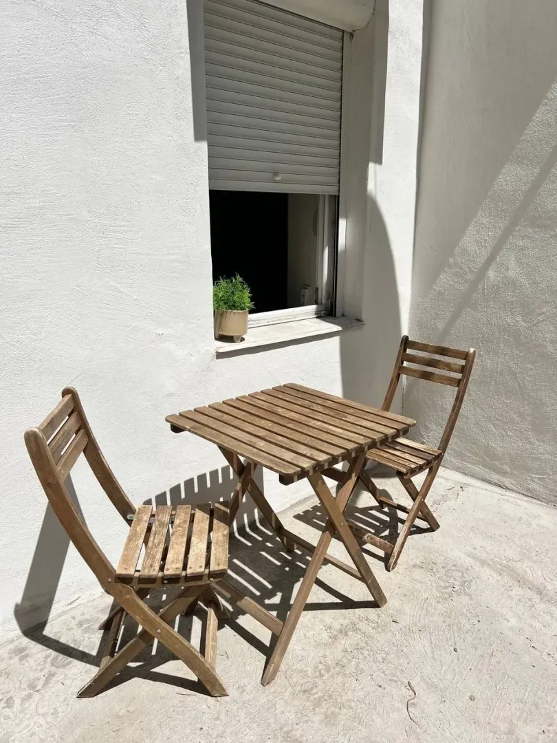 Mali drveni sto sa dvije stolice na terasi.