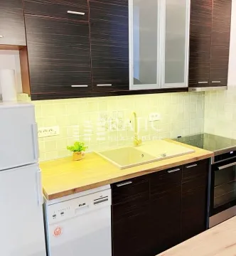 Modern kitchen with dark cabinets and white countertop. - image 3